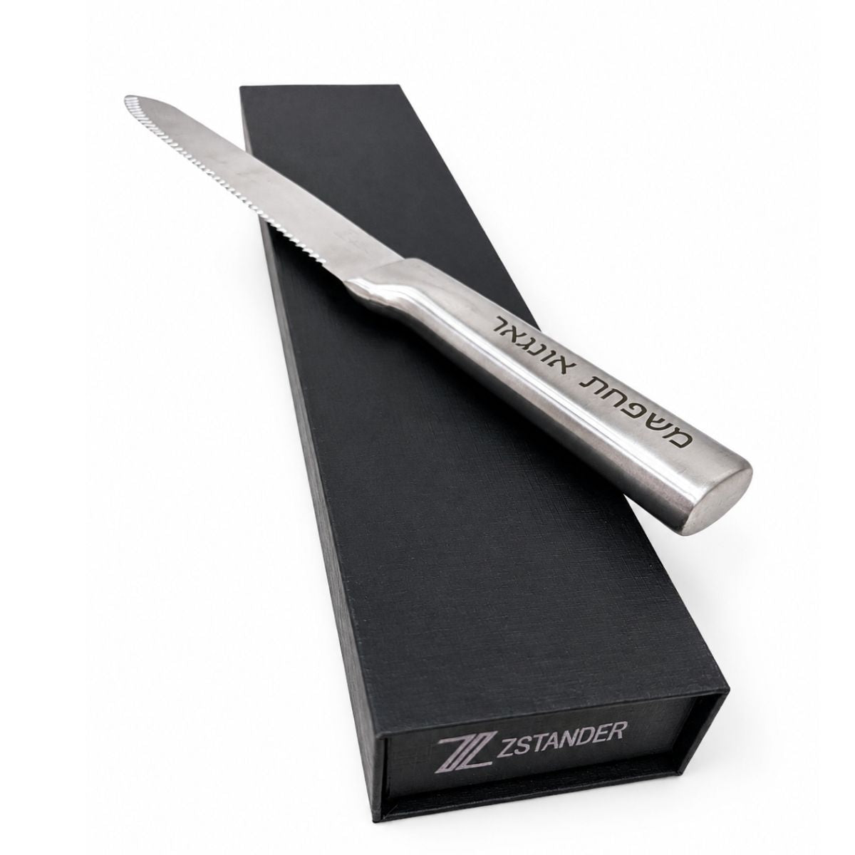 Silver bread knife with a serrated edge on a black box against a white background - Zstander