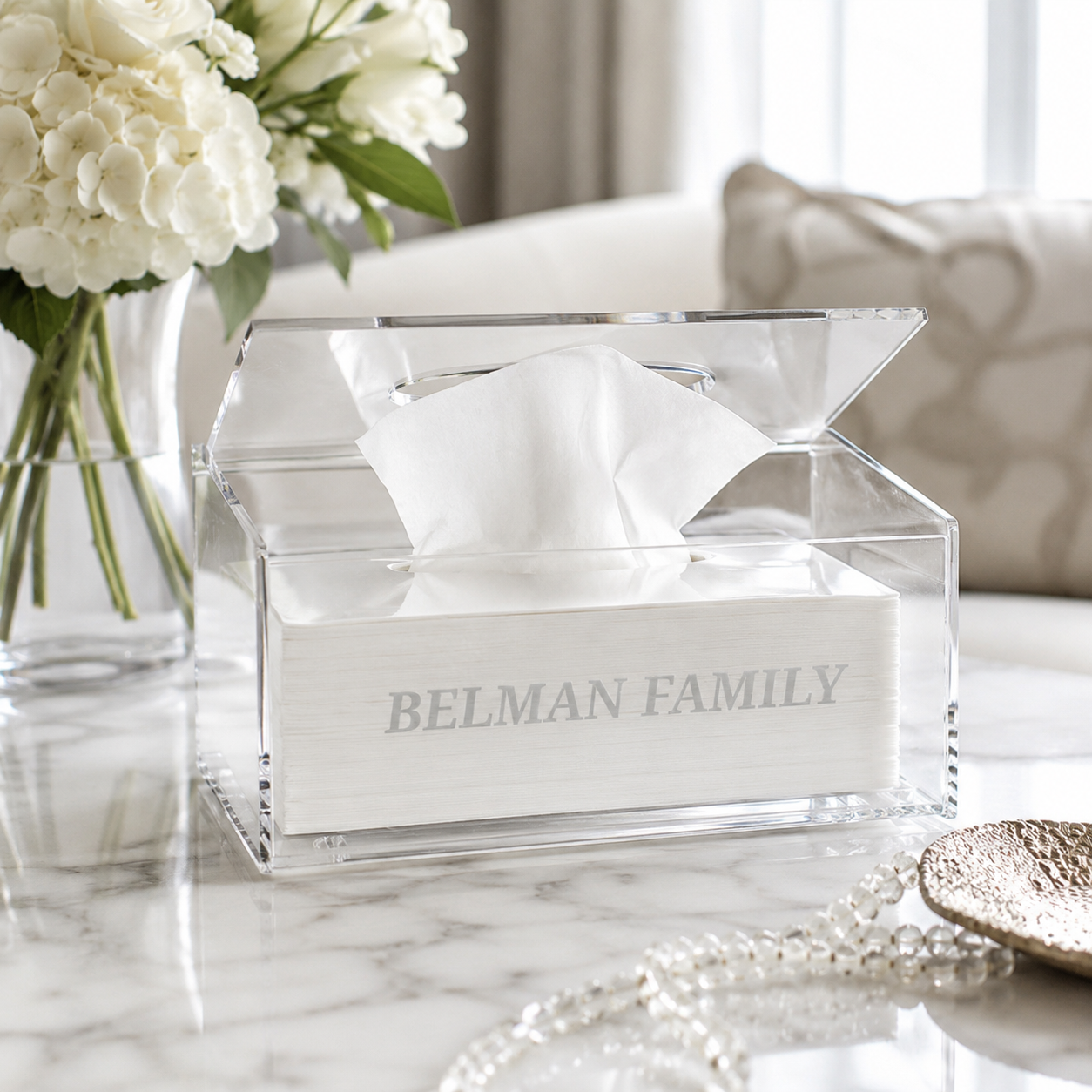 Personalized clear lucite tissue box cover with hinged lid displayed on a marble table in a modern luxury living room setting - Zstander