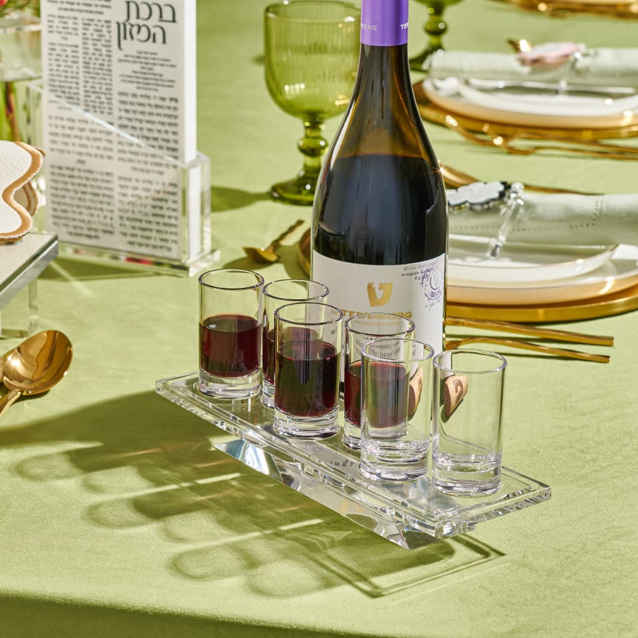 Table setting with wine bottle, glasses, and bread on a green tablecloth - Zstander