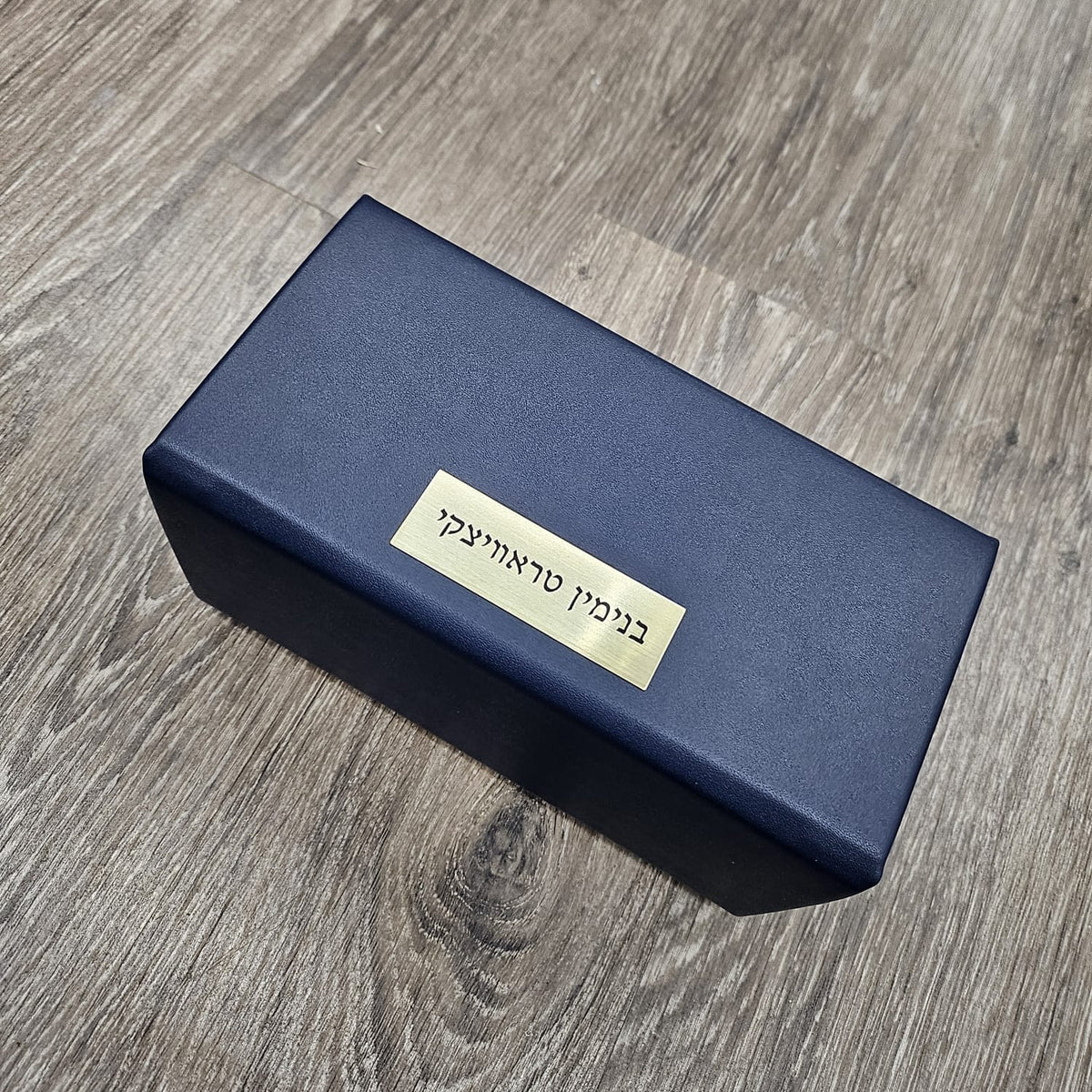 Navy esrog box with a gold name plaque on a wooden floor - Zstander