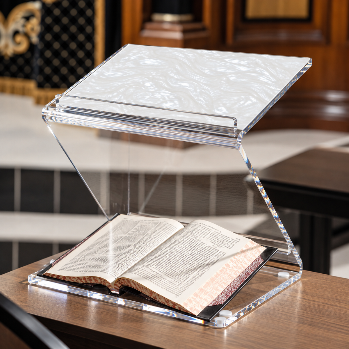 Pearl marble sit & stand shtender with a sefer open on the table in a shul.