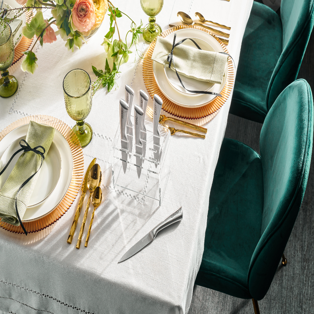 Elegant table setting with gold cutlery and green napkins on a white - Zstandertablecloth.