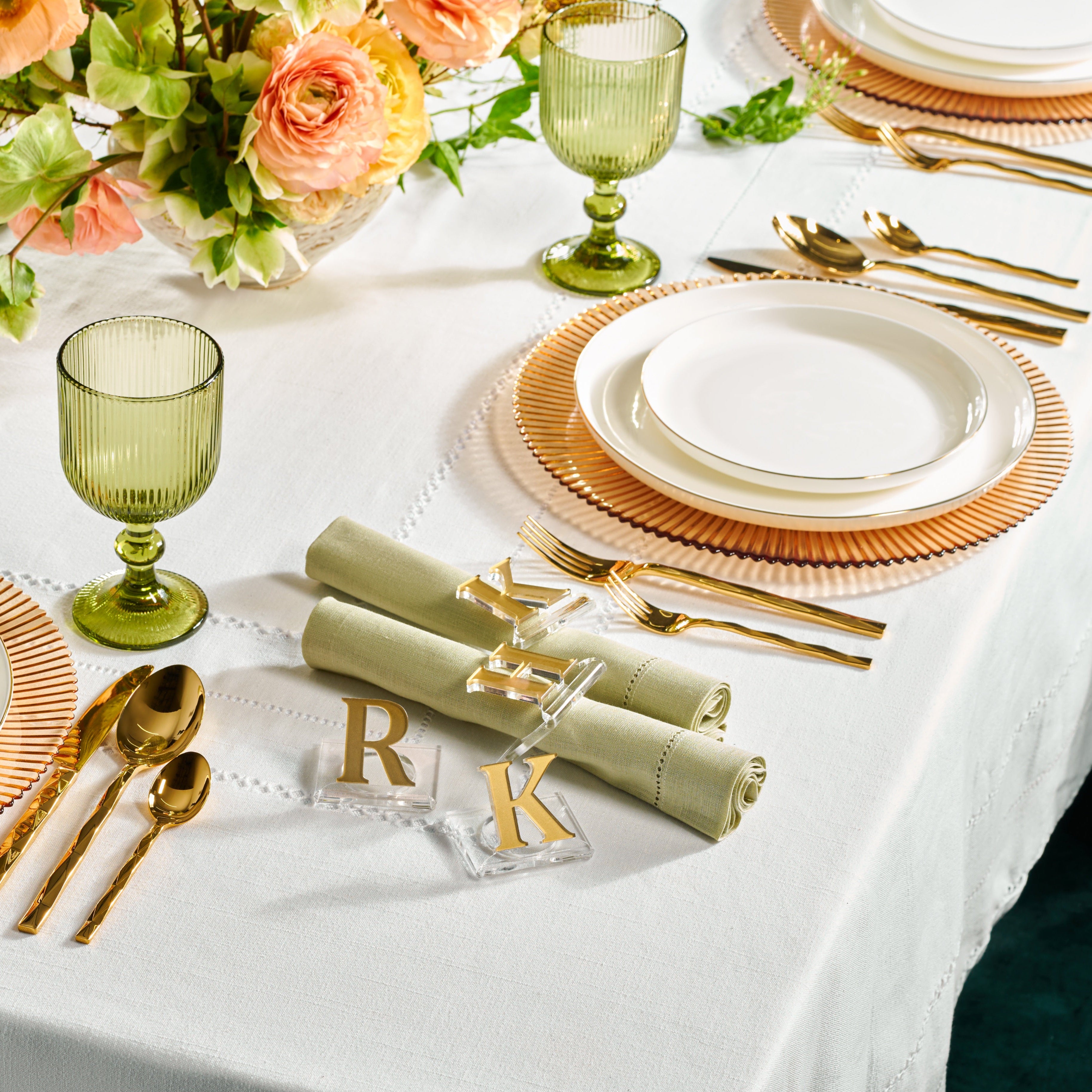 Elegant table setting with gold and white plates, glasses, and cutlery on a white tablecloth - Zstander
