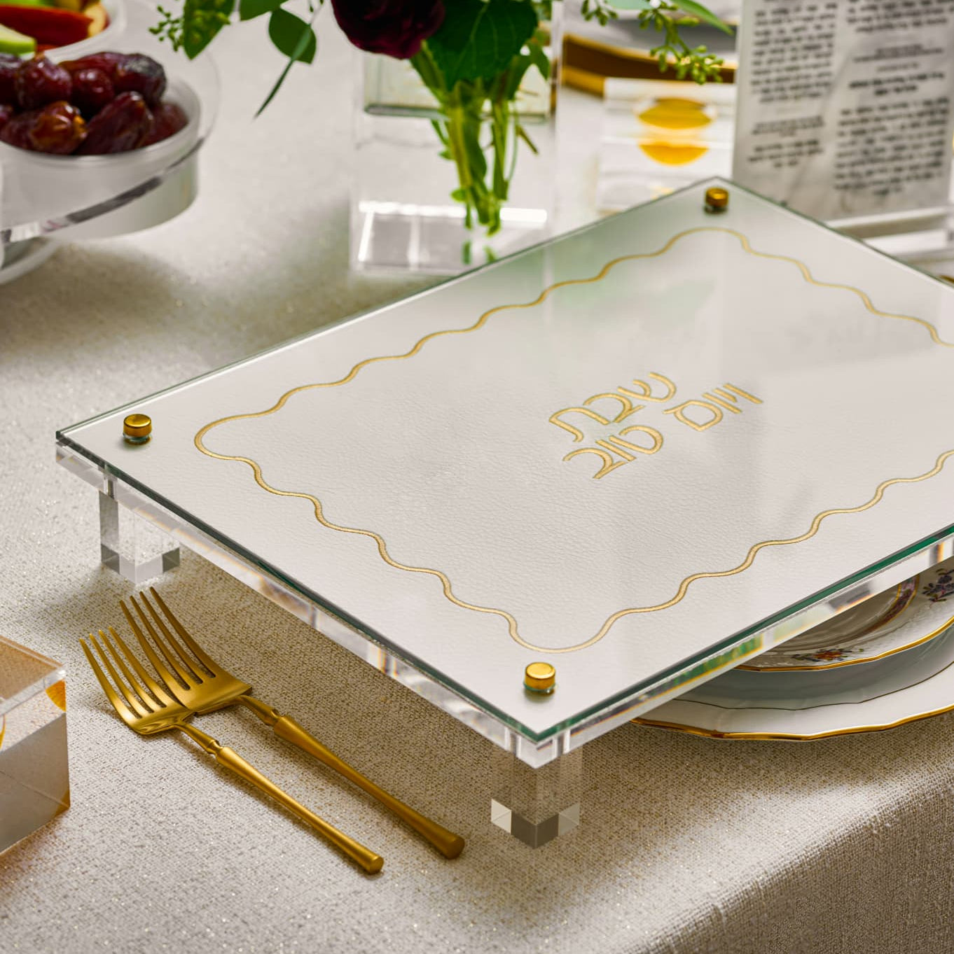 Shabbos challah board with gold accents on a table setting with gold cutlery and a vase - Zstander