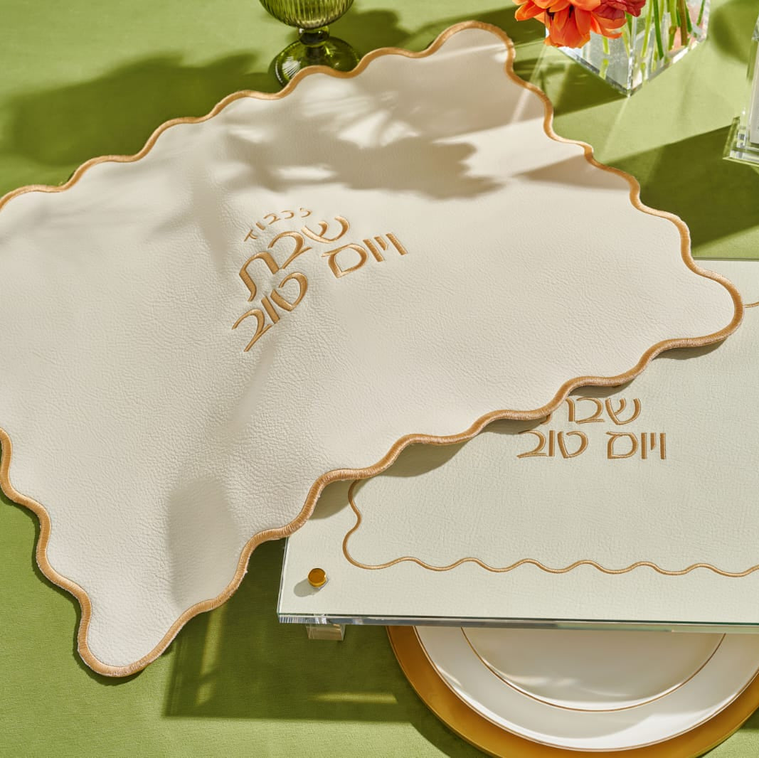 Decorative place setting with a challah board & Cover and cutlery on a green tablecloth - Zstander