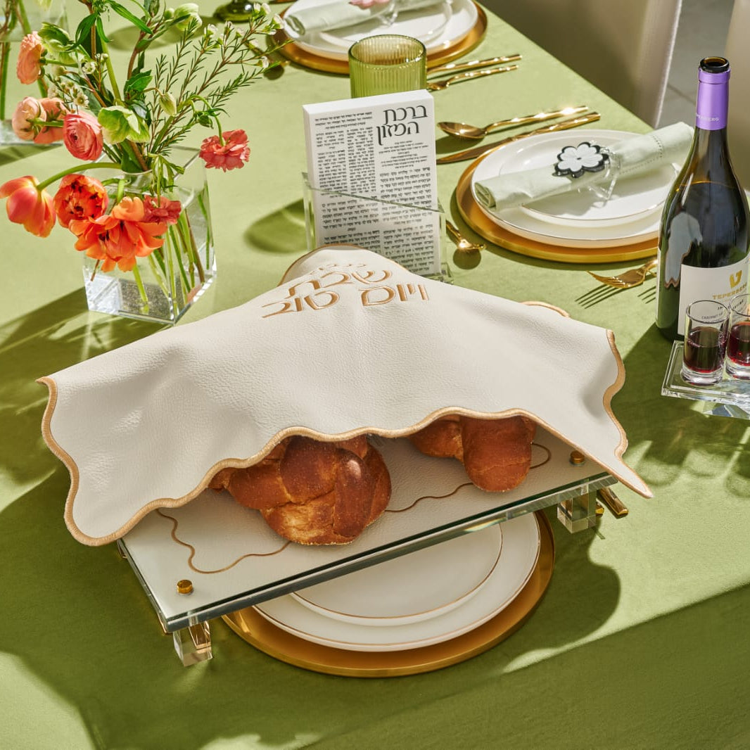 Set table with a covered dish, wine, and flowers on a green tablecloth - Zstander