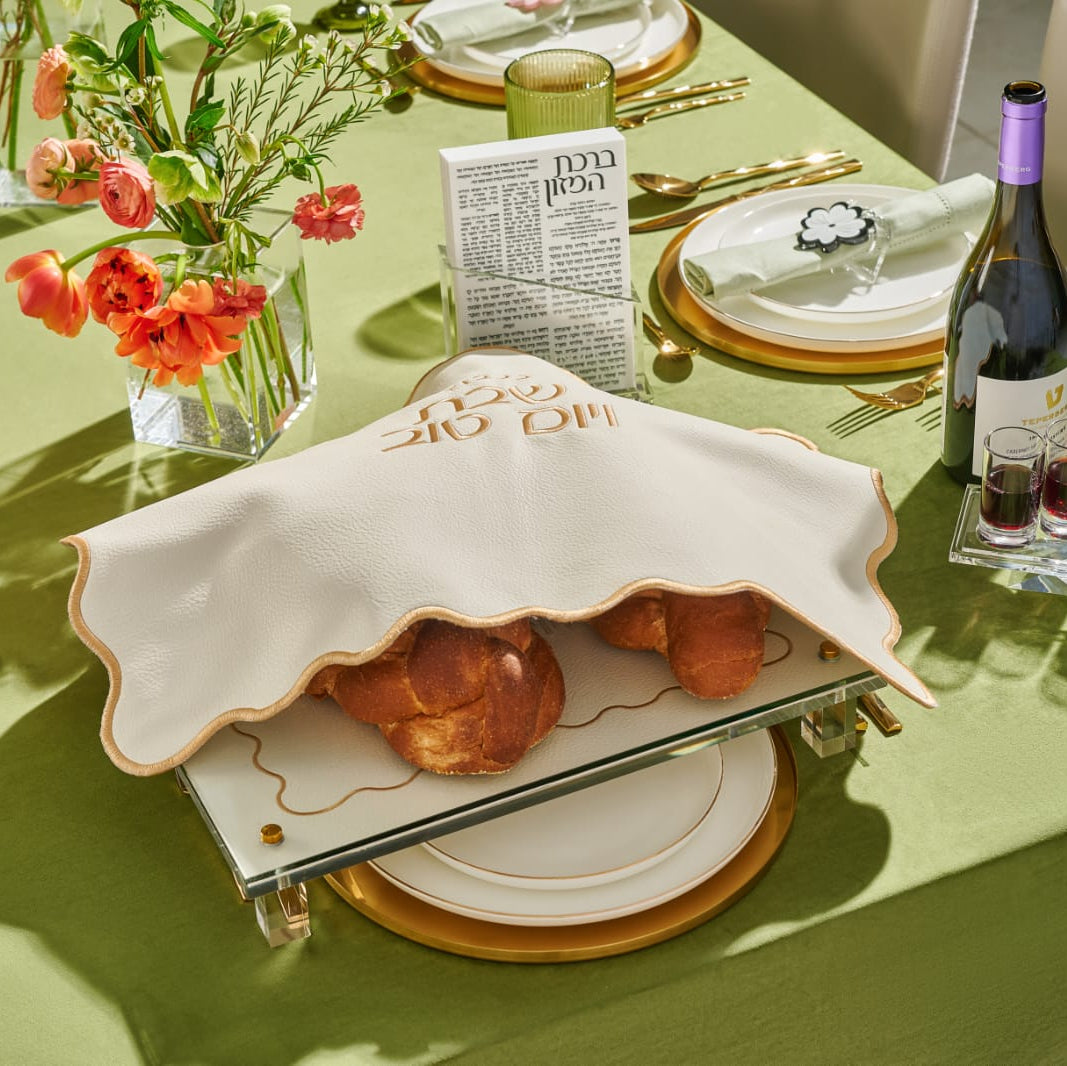 Set table with a covered dish, wine, and flowers on a green tablecloth - Zstander