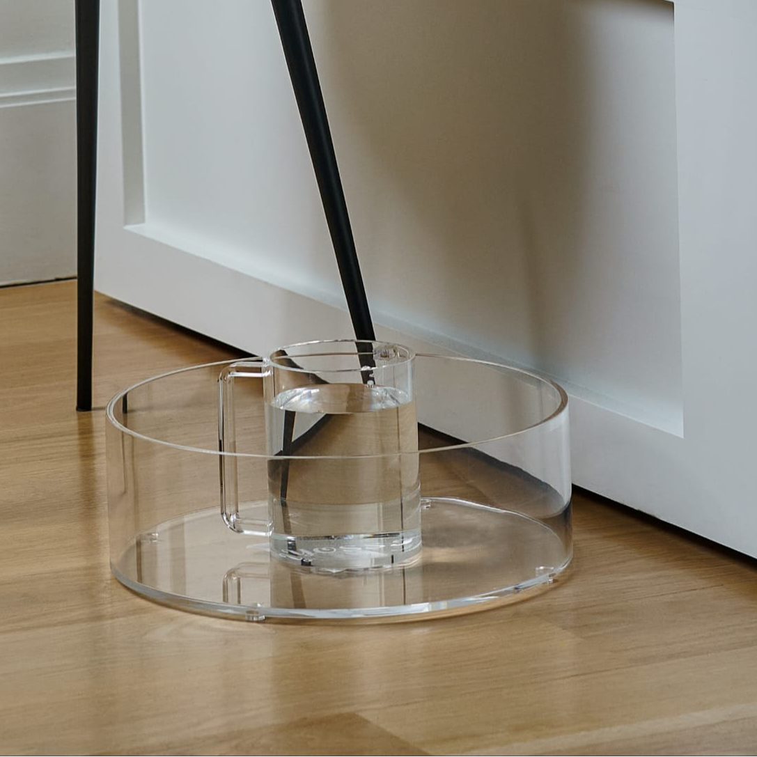 Clear lucite washing bowl & cup on a wooden floor with white cabinets in the background - Zstander