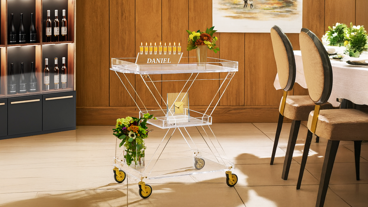 Modern bar cart with a menorah engraved with the name DANIEL in a stylish interior setting.