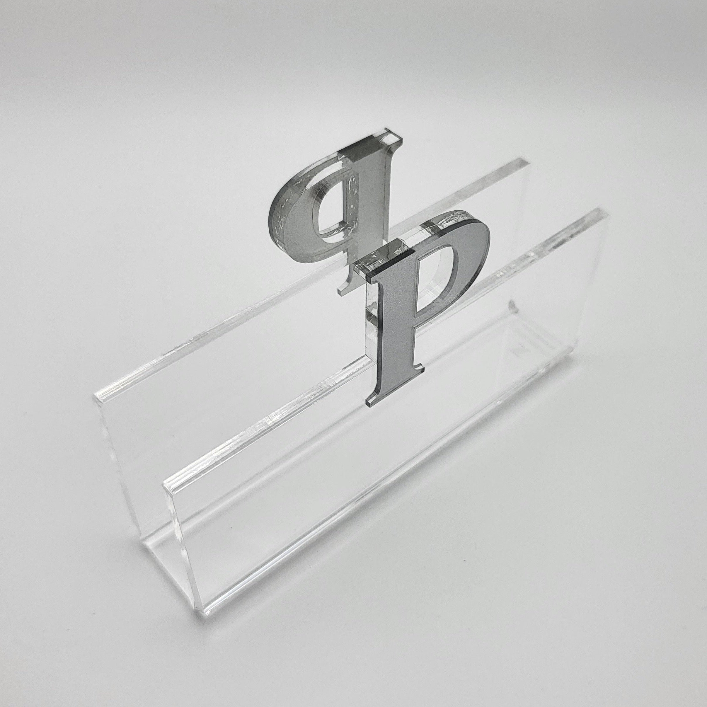top view of a Clear acrylic napkin holder with silver letter 'P' on a white background - Zstander