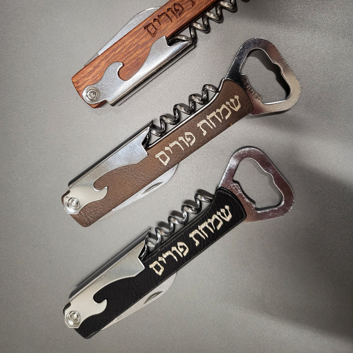 3 corkscrews on a table with Simchas Purim engraved on them,