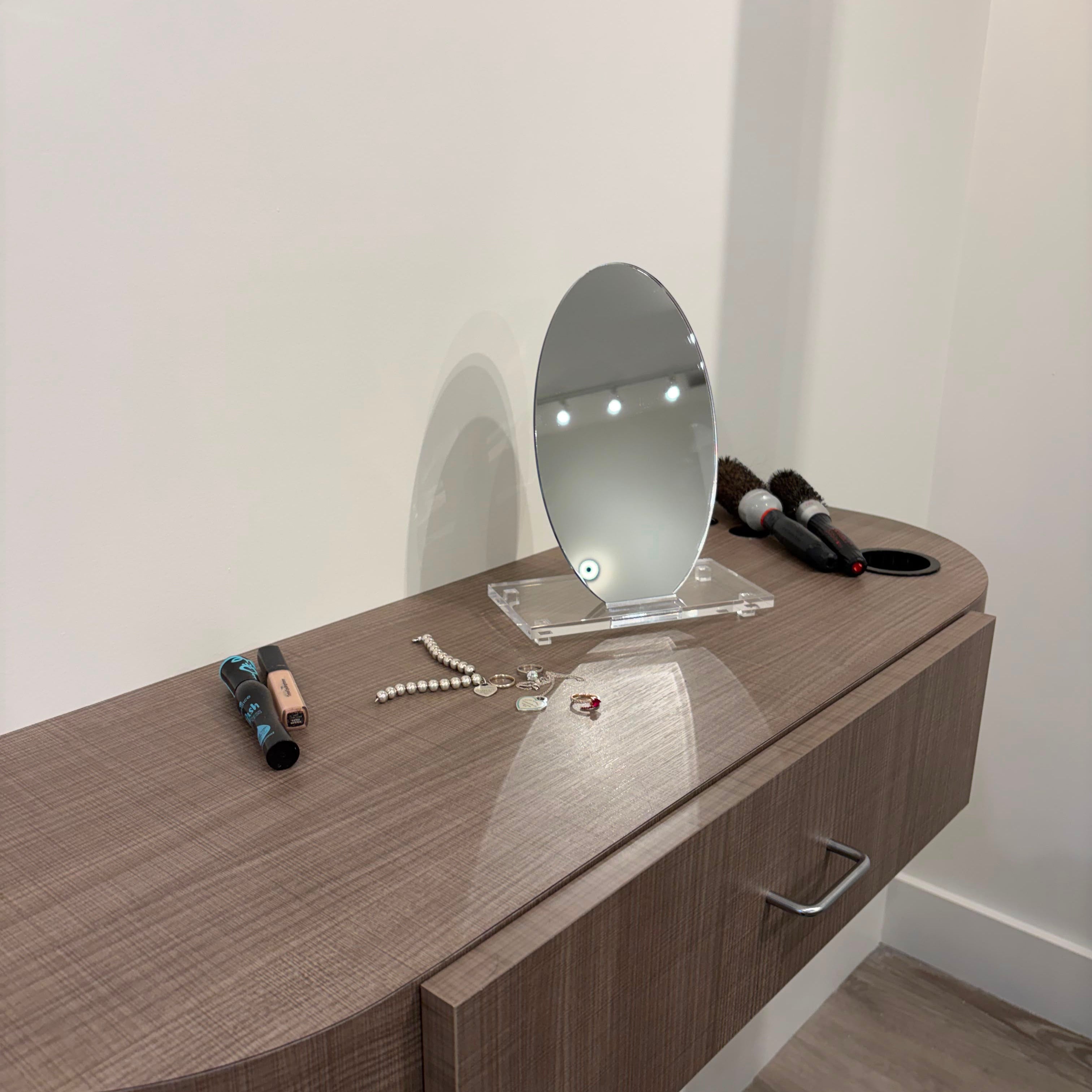 A modern floating vanity cabinet with a woodgrain finish and oval vanity mirror, shown in a minimalist room setting - Zstander