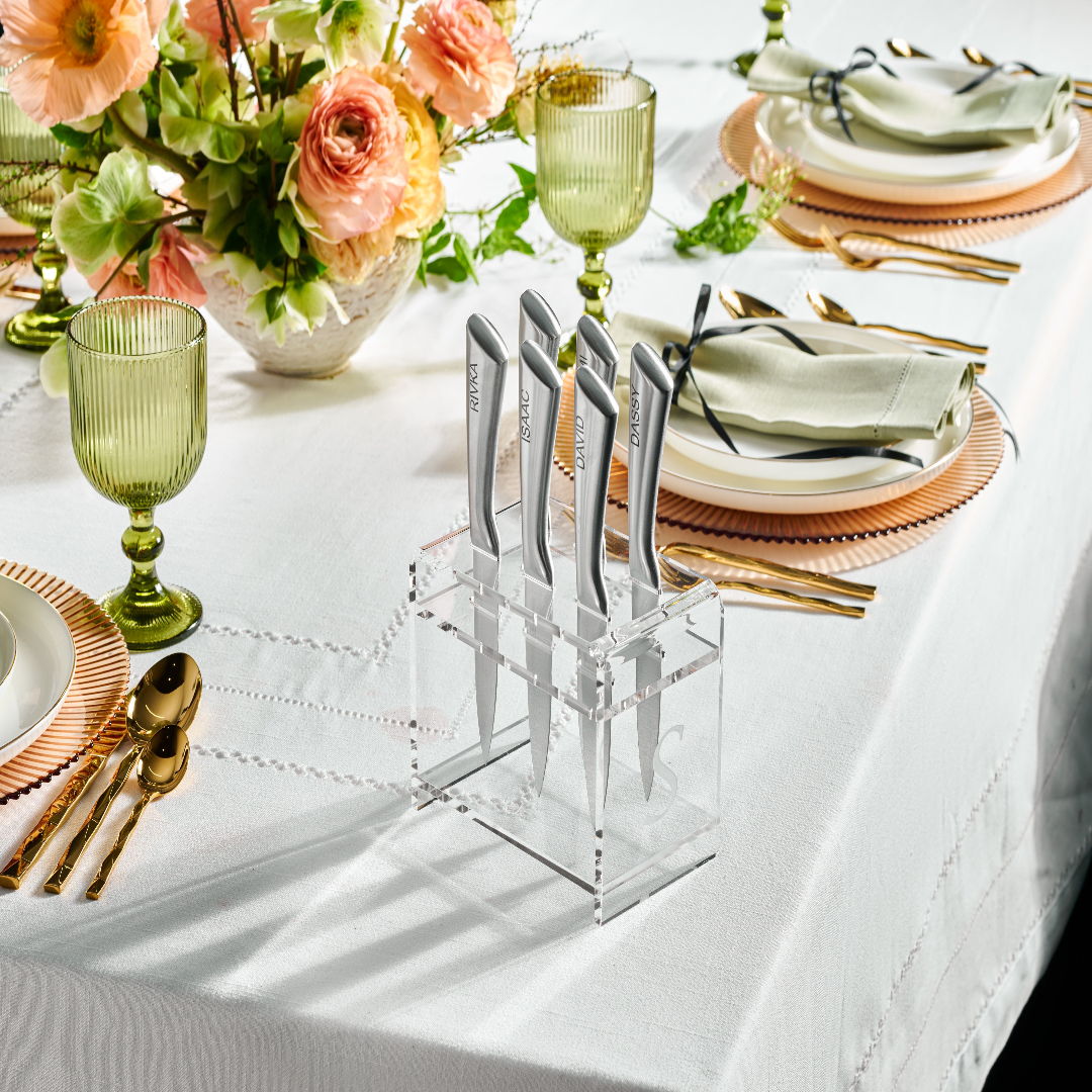 Clear acrylic knife block with silver knives on a decorated table with flowers and glasses - Zstander