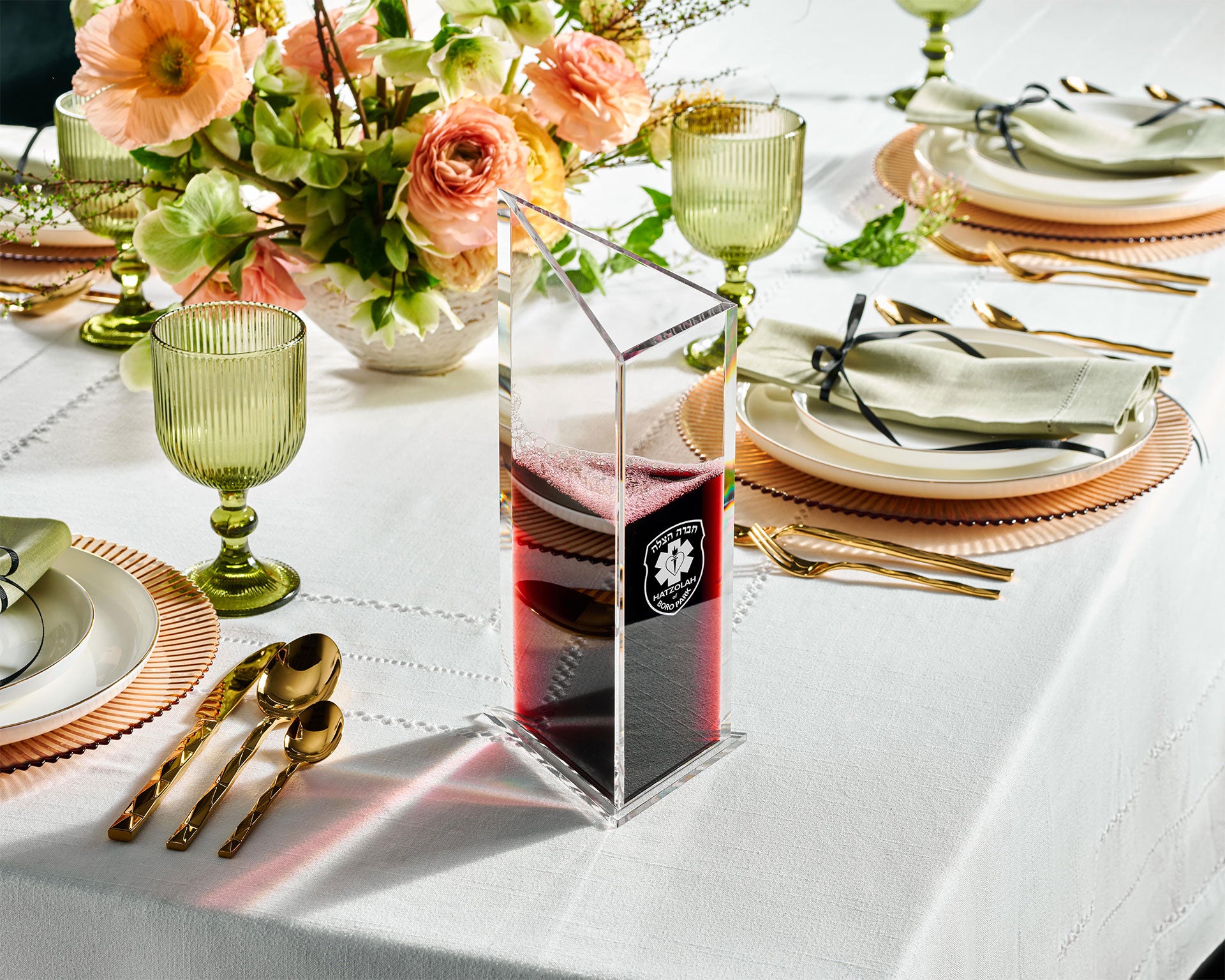 Elegant table setting with floral decorations and clear decanter with red wine.