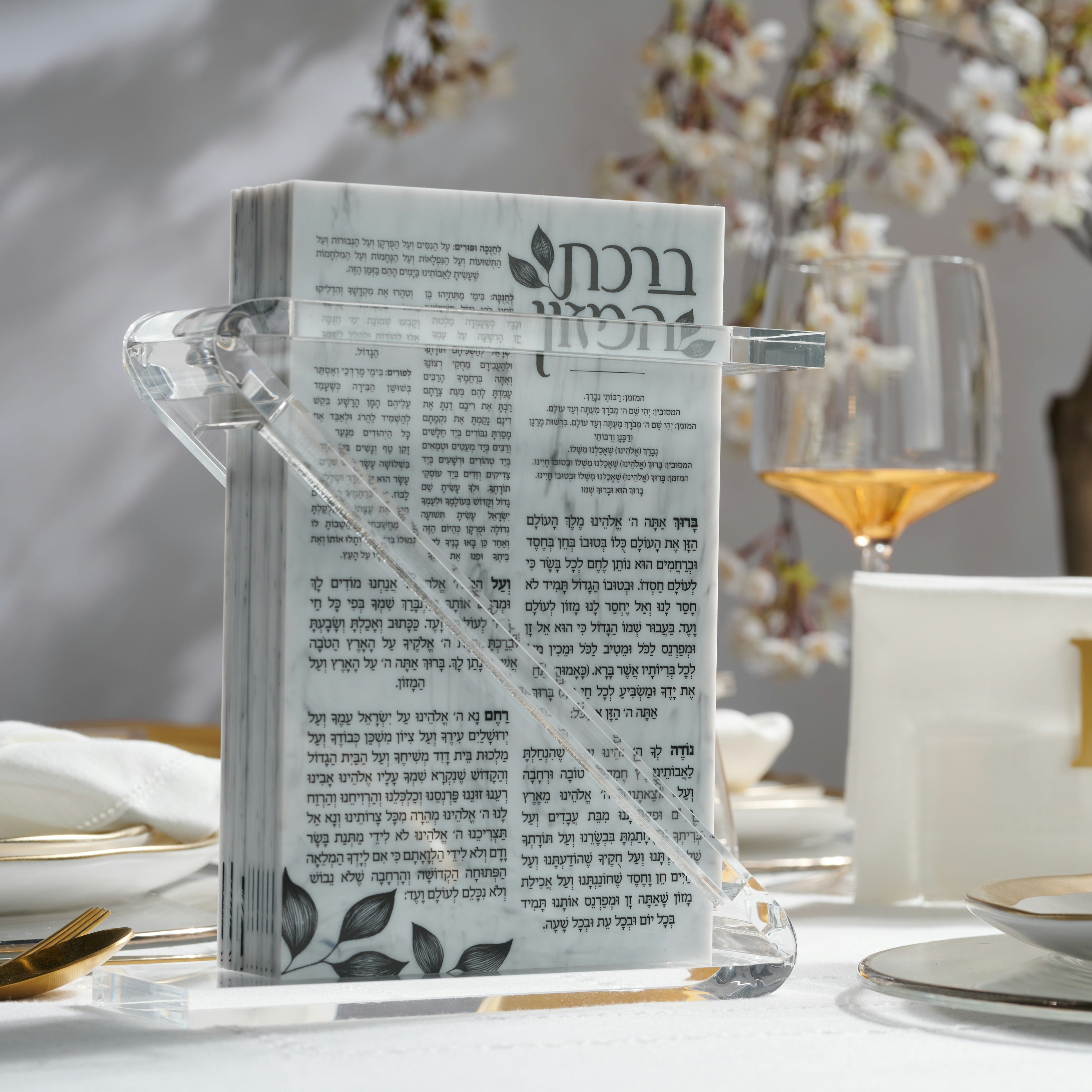 A clear acrylic year round bencher set styled on a table with a glass of white wine, gold spoon, and plates in a bright, softly blurred setting - Zstander