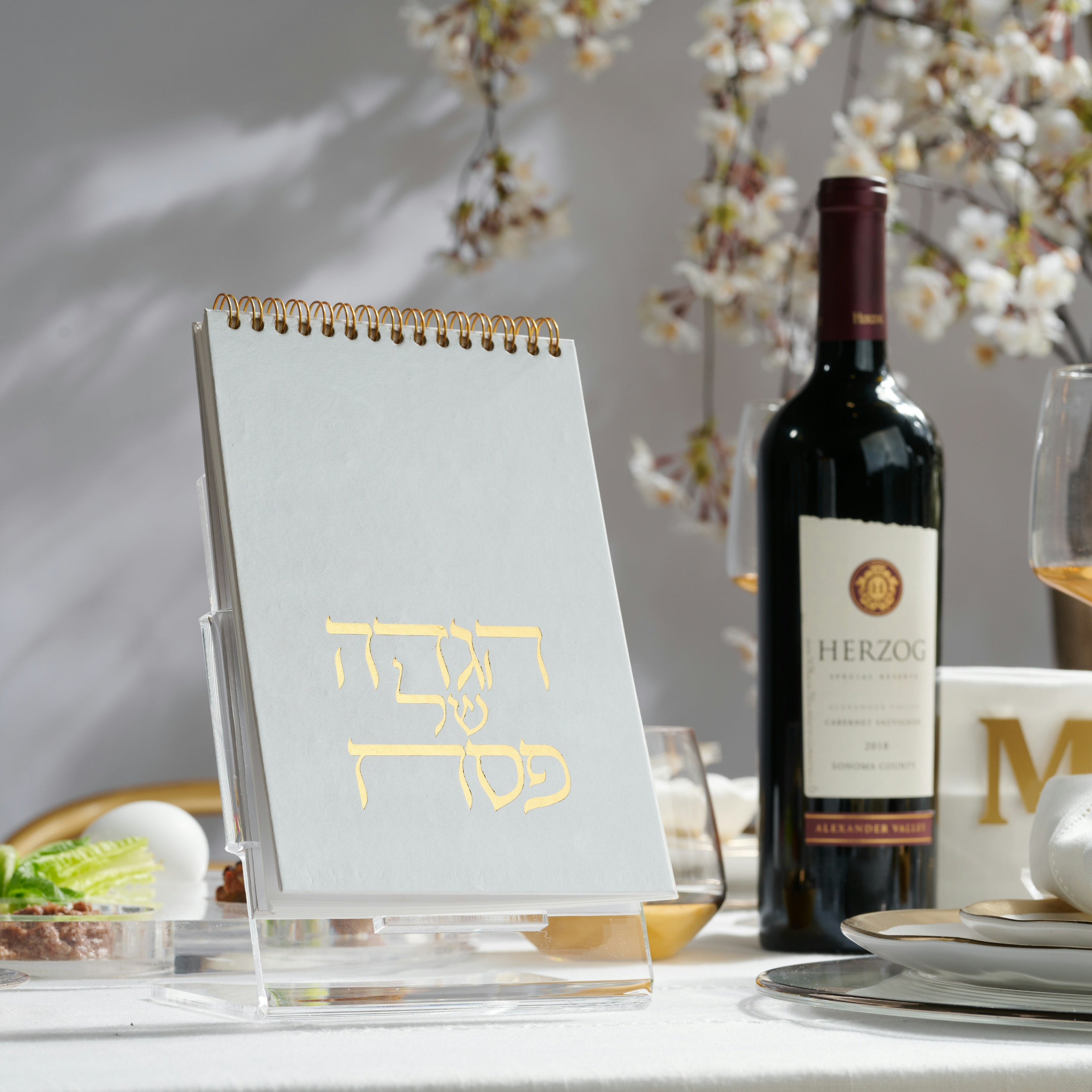 Spiral standing Haggadah on a cler lucite stand on a set Passover table - Zstander