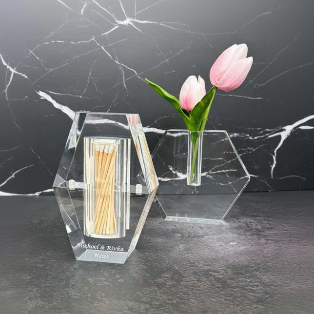 Clear hexagonal matchbox with matches and a small vase with pink tulips on a dark marble surface - Zstander