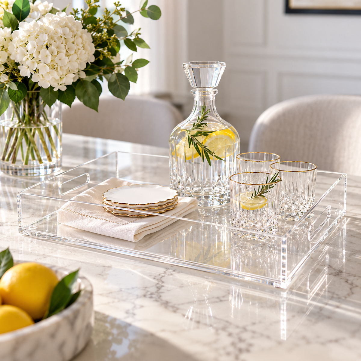 Large clear lucite serving tray set on a table wit lemon water, cups, plates napkins. 