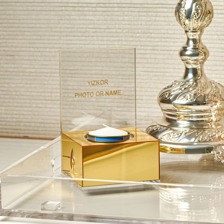 Gold and silver decorative item with 'Yizkor' text on a reflective surface - Zstander