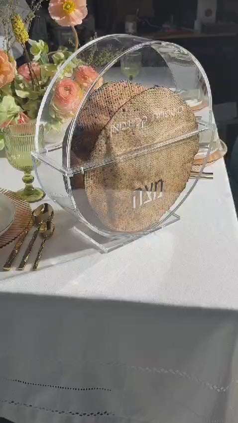 display of a round lucite matzah box on a set passover table