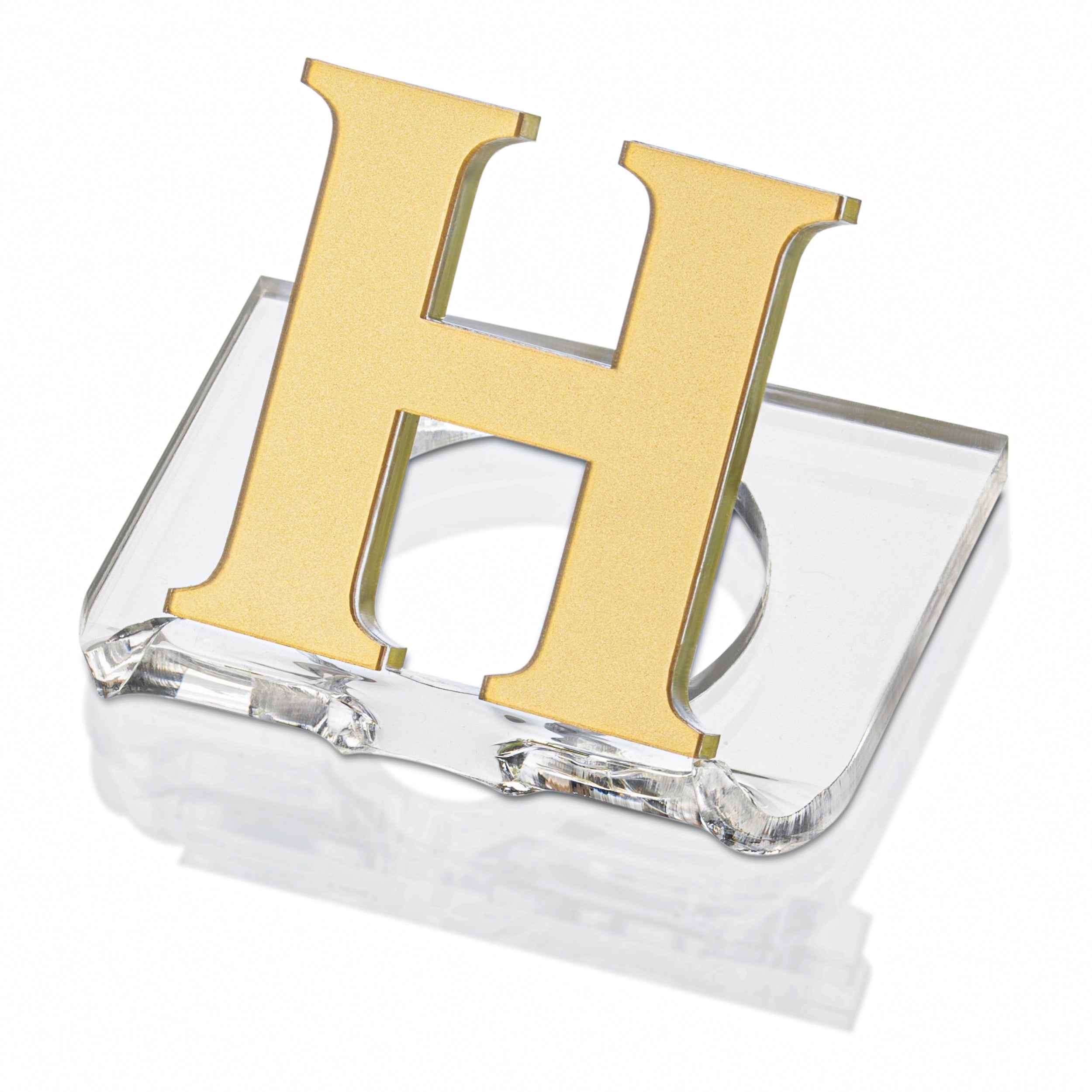 A clear lucite napkin ring with a monogrammed letter 'H' in gold - Zstander